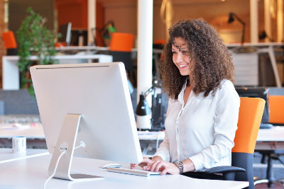 Jeune femme heureuse travaillant à un bureau ergonomique