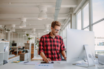 Employé travaillant debout grâce à un bureau adaptable
